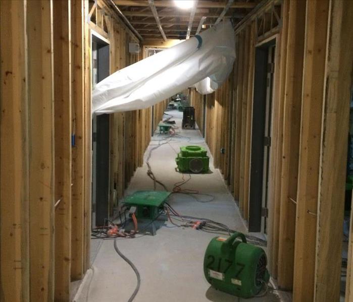 Air movers and dehumidifier in hallway.