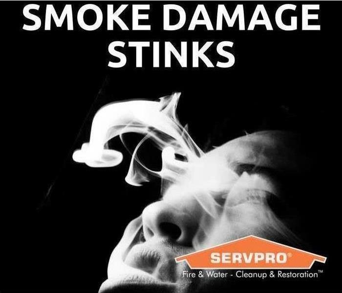 Smoke with a sign that says SMOKE DAMAGE STINKS